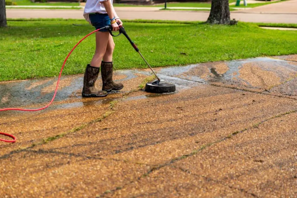 Power washing a concrete driveway