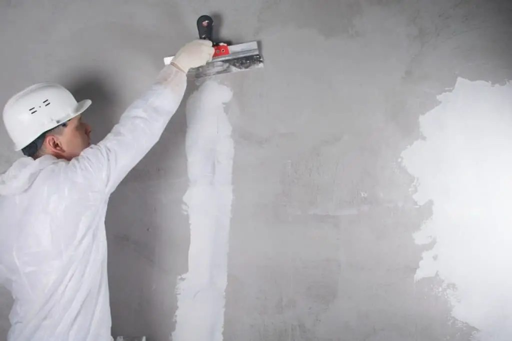 Man preparing concrete wall before painting