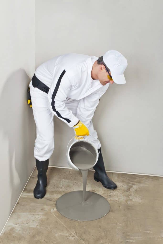 Man preparing for acid staining concrete floor.