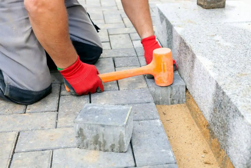 Man installing a concrete pavers to patio