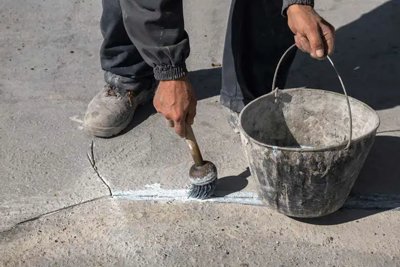 Man sealing a crack in concrete