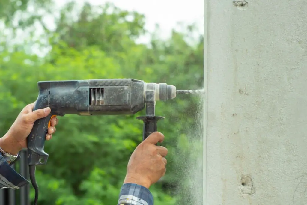 Using tools to drill into old concrete wall