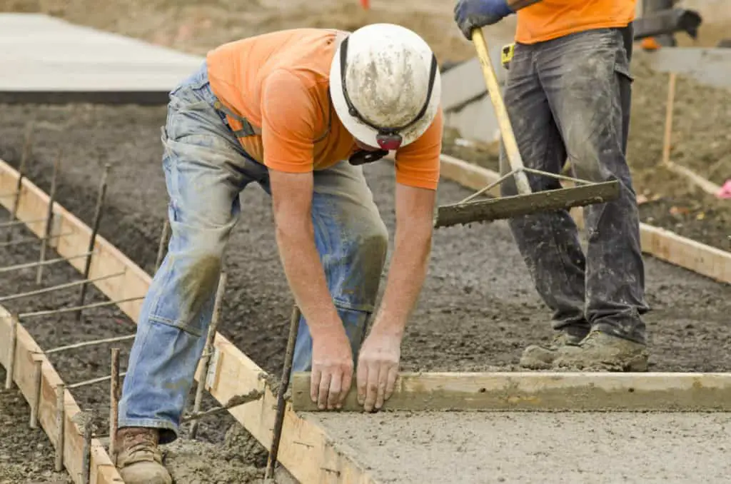 Workers building a concrete sidewalk