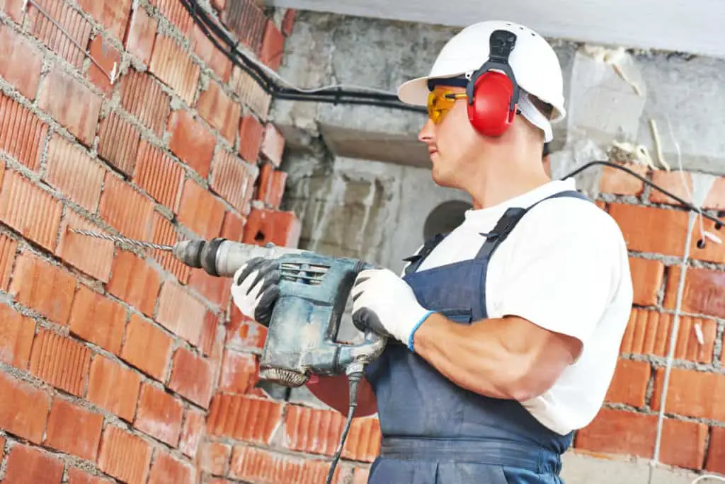 Man using a hammer drill for drilling into concrete