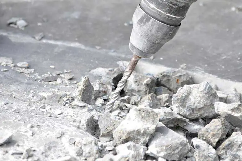 Breaking up concrete using a drill