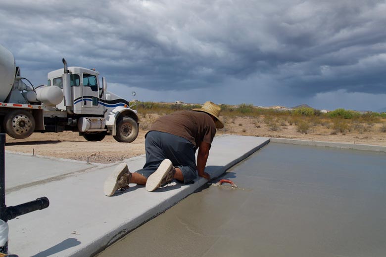 Man working with concrete in rainy weather